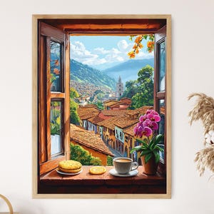 May include: A framed art print showing a colourful cityscape through an open window. The scene includes a cup of coffee, biscuits, and a potted orchid on the windowsill. The artwork depicts a town in a valley with a church steeple.