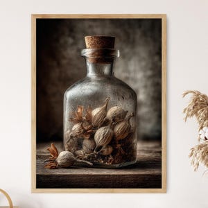 Op de afbeelding: Een ingelijste print met een vintage glazen fles gevuld met gedroogde zaaddozen en een kurk. De fles staat op een houten oppervlak, met een neutrale achtergrond. Het kunstwerk heeft een rustiek, botanisch thema.