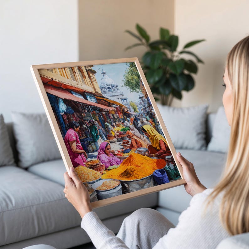May include: A framed painting depicting a bustling street market in India. The painting features vibrant colors, including yellow, orange, red, and green, and showcases a variety of spices and other goods being sold. The painting is set against a backdrop of a traditional Indian city.