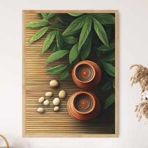 Puede incluir: Una impresión artística enmarcada que presenta dos ollas de terracota con diseños intrincados, rodeadas de hojas verdes y piedras lisas y claras. El fondo es una estera de bambú, creando una estética natural y serena. La obra de arte está enmarcada en madera clara.