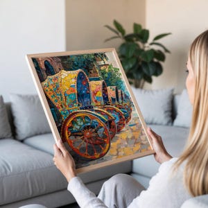 K&ouml;nnte beinhalten: Ein gerahmter Druck mit einer Reihe von farbenfroh dekorierten Pferdekutschen. Die Kutschen sind mit bunten Blumenmustern in Gelb, Blau und Orange verziert. Das Kunstwerk ist vor dem Hintergrund einer Kopfsteinpflasterstra&szlig;e und &uuml;ppigem Gr&uuml;n angeordnet.