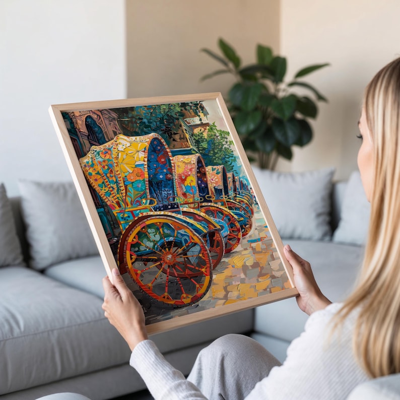 K&ouml;nnte beinhalten: Ein gerahmter Druck mit einer Reihe von farbenfroh dekorierten Pferdekutschen. Die Kutschen sind mit bunten Blumenmustern in Gelb, Blau und Orange verziert. Das Kunstwerk ist vor dem Hintergrund einer Kopfsteinpflasterstra&szlig;e und &uuml;ppigem Gr&uuml;n angeordnet.