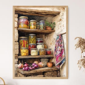 Puede incluir: Impresión enmarcada de una escena de despensa rústica. Estantes de madera exhiben varios frascos de vidrio llenos de coloridas verduras encurtidas y conservas. Un paño estampado cuelga cerca, con cebollas y un cuenco pequeño en un estante inferior.