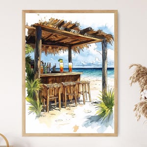 May include: Watercolor painting of a beach bar with a thatched roof, wooden stools, and a bar counter. Two cocktails sit on the bar. The background shows the ocean and sky. The artwork is framed in a light brown wooden frame.