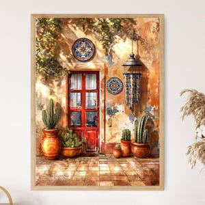 May include: A framed print of a sunlit exterior scene. A red door is centered, flanked by potted cacti and terracotta pots. Decorative plates and a hanging lantern adorn the textured, orange-toned wall. The scene evokes a warm, Southwestern aesthetic.