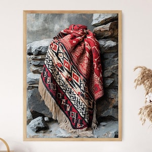 May include: A framed image of a red, black, and cream-colored woven textile with a geometric pattern and fringe. The textile is draped over a stone wall, creating a rustic and textured aesthetic. The artwork is a decorative piece.