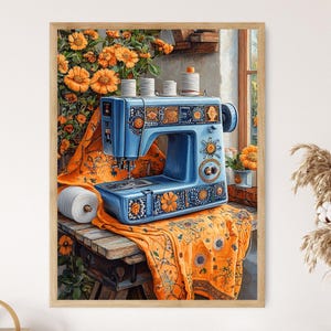Puede incluir: Impresión enmarcada de una máquina de coser azul vintage con patrones florales y geométricos. La máquina está sobre una mesa de madera cubierta con una tela naranja con motivos florales. También se ven carretes de hilo y un gran rollo de hilo blanco.