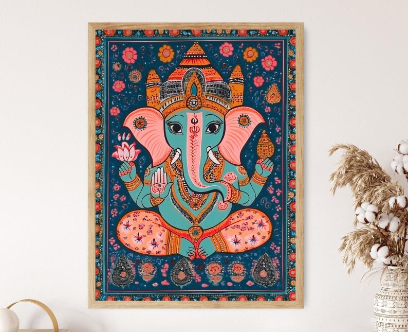 May include: A framed illustration of the Hindu deity Ganesha, depicted in a colorful, traditional style. The image features Ganesha with a blue body, pink ears, and a yellow crown, sitting in a meditative pose. The background is a dark blue with floral patterns and intricate details.