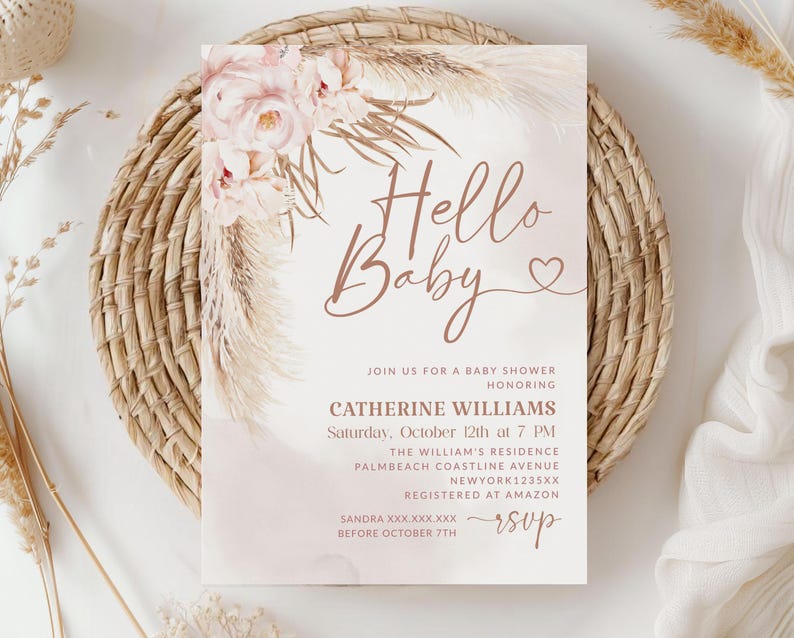 May include: A baby shower invitation with the words "Hello Baby" in a delicate script. The invitation features floral and pampas grass accents in soft pink and beige tones. Details include the honoree's name, date, time, and location.