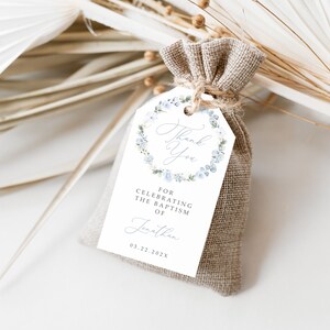 May include: White favour tag with a blue floral wreath and the text "Thank You" in a script font. The tag also includes the text "For celebrating the baptism of Jonathan 03.22.202X".