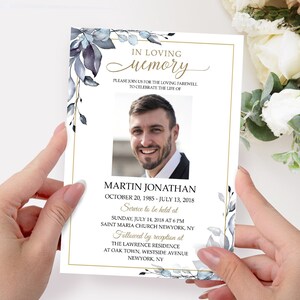 May include: A white memorial card with a gold border and blue watercolor floral design. The card features a photo of a man, the text "In Loving Memory", and the name "Martin Jonathan". The card also includes the dates "October 20, 1985 - July 13, 2018" and details about a service and reception.