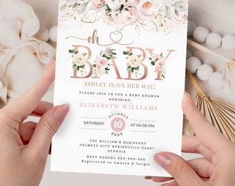 Op de afbeelding: Roze en gouden babyborrel uitnodiging met een bloemenontwerp. De uitnodiging zegt "Oh Baby" met een hartje en "Ashley is on her way!" Het bevat de datum, tijd en locatie van het evenement. RSVP-informatie is ook inbegrepen.