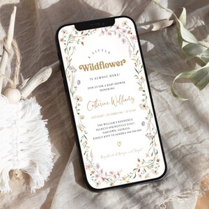 Puede incluir: Una invitación digital con un borde floral en tonos rosa y verde. El texto dice "A Little Wildflower is Almost Here!" con una corona floral dorada alrededor del texto. La invitación es para un baby shower en honor a Catherine Williams el sábado 19 de octubre a las 10:00 AM. La ubicación es The William's Residence, Palmetto Springville G2567, Oaktown, Georgia. Por favor, confirma tu asistencia a Sandra al 000-000-000. La invitación también incluye el texto "Registered at Amazon and Target".