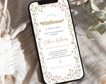 May include: A digital invitation with a floral border in shades of pink and green. The text reads "A Little Wildflower is Almost Here!" with a gold floral wreath around the text. The invitation is for a baby shower honoring Catherine Williams on Saturday, October 19th at 10 AM. The location is The William's Residence, Palmetto Springville G2567, Oaktown, Georgia. RSVP to Sandra at 000-000-000. The invitation also includes the text "Registered at Amazon and Target".