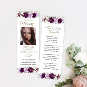May include: A purple and white floral bookmark with a photo of a woman and the text "In Loving Memory Jennifer Lawrence October 20, 1985 - July 13, 2018" and "Your life was a blessing, your memory a treasure. You are loved beyond words and missed beyond measure." on the left side. The right side of the bookmark has the text "Never Forgotten" and a poem about remembering someone who has passed away.
