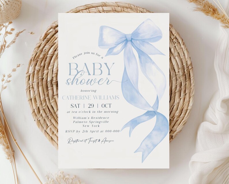 May include: A baby shower invitation with a light blue watercolor bow and ribbons. The invitation includes the text "BABY shower" and details for Catherine Williams' shower on October 29th. The invitation is on a white background.