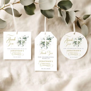 Op de afbeelding: Drie witte cadeaulabels met een bloemenkruisontwerp en de tekst "Thank You" in gouden script. De labels zijn voor Jonathan's Eerste Heilige Communie, met de datum 22-03-2025. Elk label heeft een wit lint.