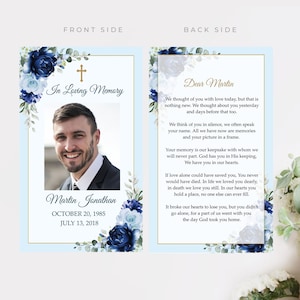 May include: A memorial card with a photo of a man, framed by blue floral arrangements and a gold border. The front reads "In Loving Memory" and the back includes a heartfelt message. The card is light blue.