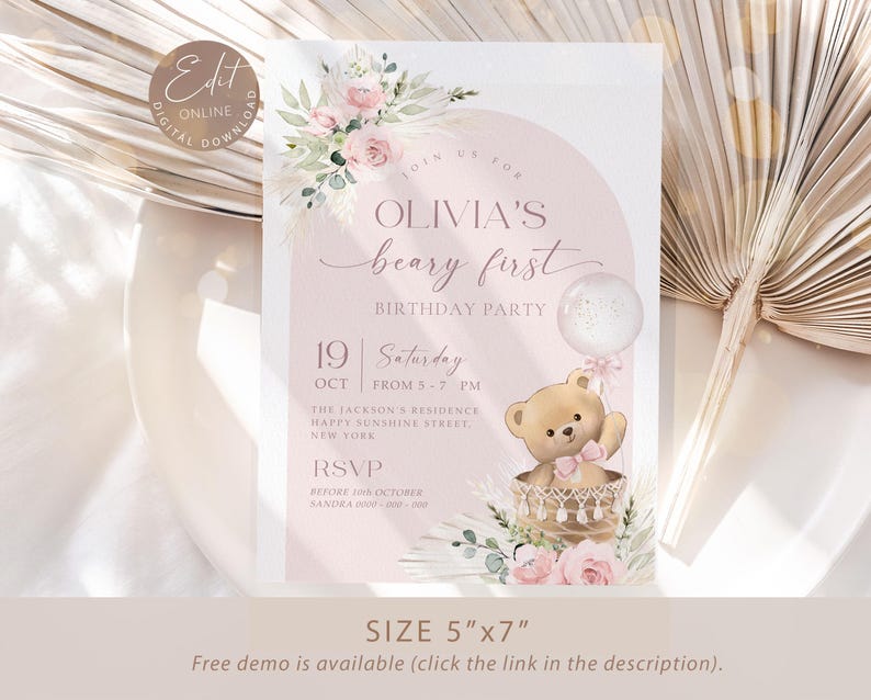 Pink floral first birthday invitation featuring a teddy bear in a basket, pastel flowers, and a balloon for a baby girl's Beary First birthday party