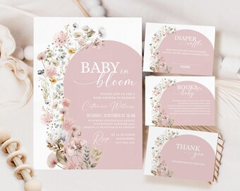 May include: A set of baby shower invitations with a pink and white floral design. The invitations feature the text "Baby in Bloom" and include details about the event, such as the date, time, and location. The invitations also include a diaper raffle card, a books for baby card, and a thank you card.