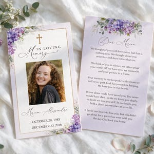 May include: Two rectangular funeral memorial cards featuring a light purple floral border with white roses and lilac flowers. The left card displays a photograph of a person, the text In Loving Memory, the name Miriam Alessandra, and dates.