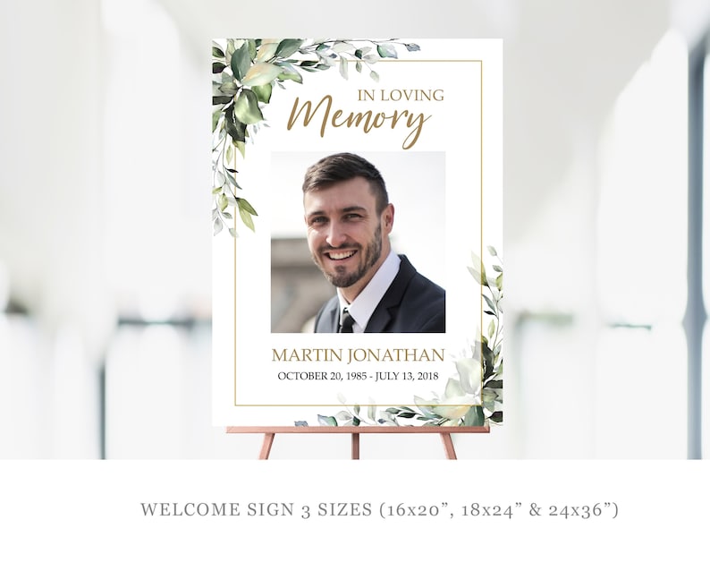 May include: A white welcome sign with a gold frame and green floral accents. The sign reads "In Loving Memory" with a photo of a man and the text "Martin Jonathan October 20, 1985 - July 13, 2018". The sign is available in three sizes: 16x20 inches, 18x24 inches, and 24x36 inches.