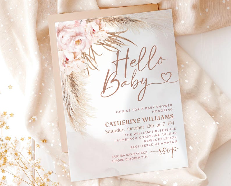 May include: A baby shower invitation with the words "Hello Baby" in elegant script. The invitation features floral and pampas grass accents in soft pink and beige tones. Details include the honoree's name, date, time, and location.