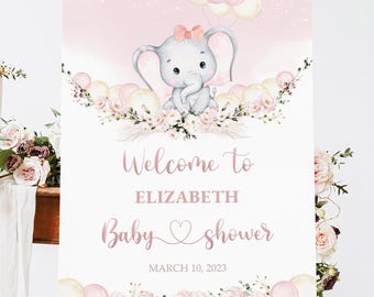 May include: A pink and white baby shower welcome sign with a cute cartoon elephant holding balloons. The sign says "Welcome to Elizabeth Baby Shower March 10, 2023".