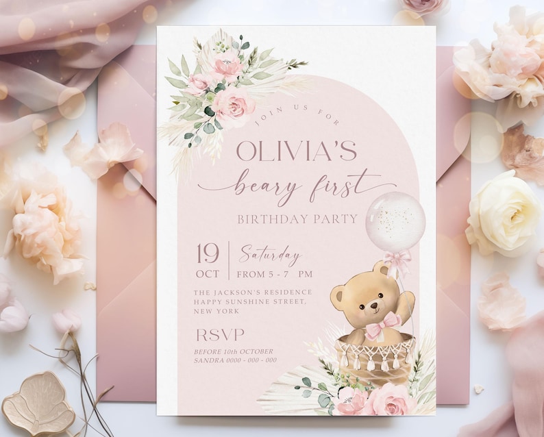 Pink floral first birthday invitation featuring a teddy bear in a basket, pastel flowers, and a balloon for a baby girl's Beary First birthday party