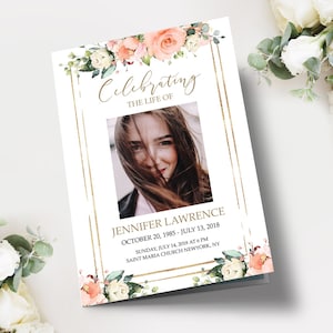May include: A memorial program with a photo of Jennifer Lawrence, framed by gold lines and floral accents. The text reads "Celebrating the Life of Jennifer Lawrence" with dates and location details. Peach and white flowers adorn the top and bottom.