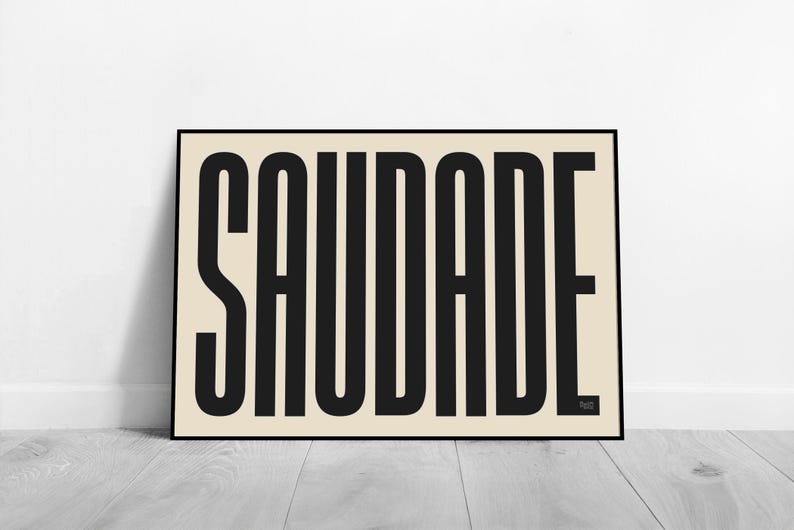 May include: A black and white poster with the word "SAUDADE" printed in bold, block letters on a cream background.