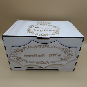 May include: A white wooden box with a decorative design and the text "Damen-hygiene woman only" on the front.