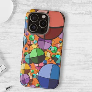 May include: A colorful phone case featuring a vibrant abstract design. The case has an orange background with overlapping circles in shades of blue, green, purple, and yellow. The phone case has a camera cutout.