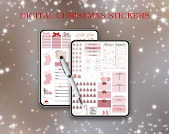 Op de afbeelding: Twee digitale tablets met stickers met kerstthema. De stickers hebben roze en witte ontwerpen, waaronder geschenkdozen, kousen, kerstbomen en kalenderelementen. Een zilveren pen ligt op de tablets en de tekst "DIGITAL CHRISTMAS STICKERS" staat bovenaan.