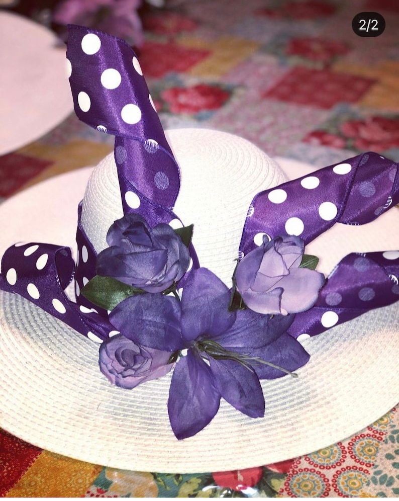 以下が含まれることがあります： 白い麦わら帽子に、白のドット模様の紫のリボンと紫の花が飾られています
