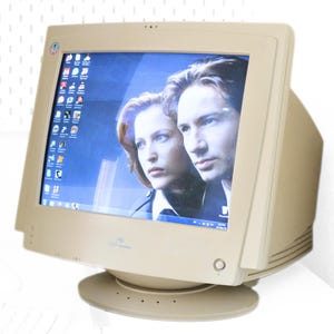 May include: Beige CRT computer monitor with a screen displaying a photo of two people. The monitor has a rounded base and a power button. The screen shows a Windows desktop with various icons.
