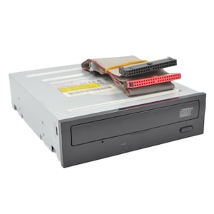 May include: An internal optical disc drive with a silver metal casing and a black front panel featuring a Compact Disc logo. A grey ribbon cable with a red connector and a black connector is folded on top of the drive, secured by a yellow rubber band.