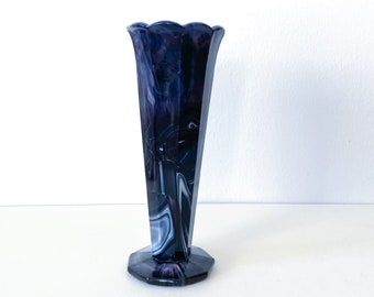 May include: A purple and white swirled glass vase with a scalloped top and a hexagonal base.