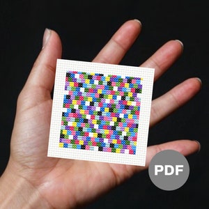 May include: A colorful cross-stitch pattern with a variety of colors, including pink, blue, green, yellow, and black. The pattern is on a white background and is framed with a white border. The pattern is labeled "PDF" in the lower right corner.