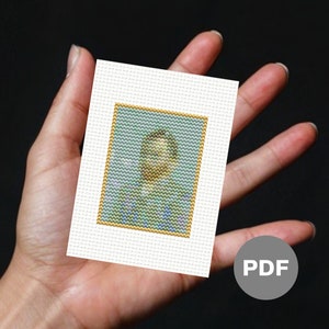May include: A cross-stitch pattern featuring a portrait of a person with a blue background and a gold frame. The pattern is printed on white paper and is ready to be stitched.
