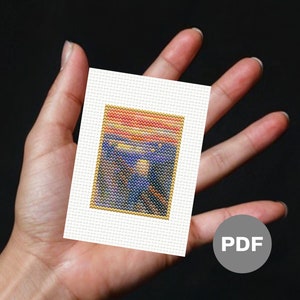 May include: A cross-stitch pattern of The Scream painting by Edvard Munch. The pattern is printed on white Aida cloth and features a colourful depiction of the iconic painting.