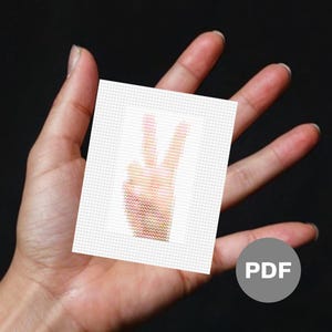 May include: A white card with a peace sign in the centre. The peace sign is made of small, colourful squares. The card is being held in a person's hand. The word "PDF" is printed on a grey circle in the bottom right corner of the image.