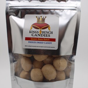 May include: A silver resealable bag filled with freeze-dried Queen Bees Batch candy. The bag has a label with a crown and the text "Kings Bench Candies". Made in a cottage food operation that is not subject to state food safety inspections.