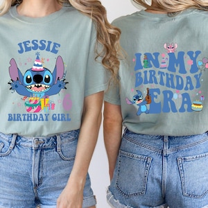 May include: A light blue t-shirt with a cartoon Stitch character wearing a party hat and holding a cake. The text "Jessie Birthday Girl" is printed on the front of the shirt. The back of the shirt has the text "In My Birthday Era" with a Stitch character playing a guitar.