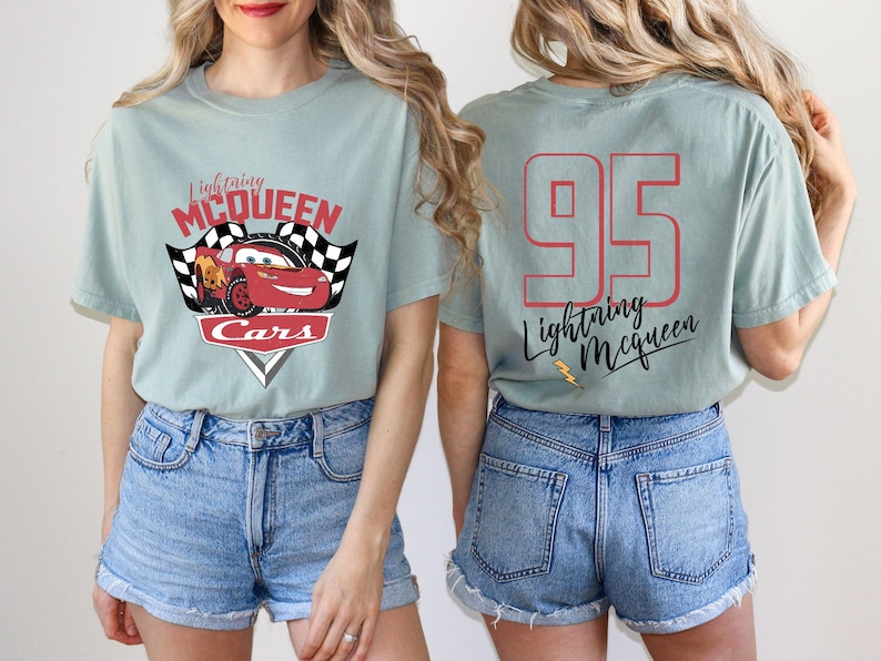 May include: Light blue t-shirt with a red race car graphic and the text "Lightning McQueen Cars". The back of the shirt has the number "95" and the text "Lightning McQueen".