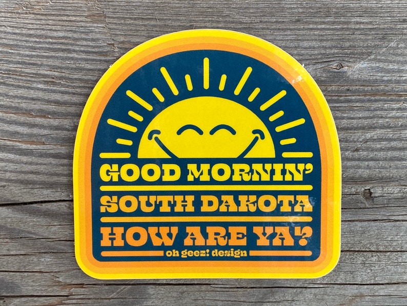 May include: Yellow and blue sticker with a smiling sun and the text "Good Mornin' South Dakota How Are Ya?"  - oh geez! design