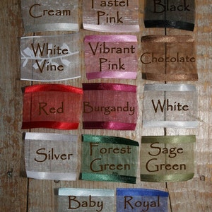 Puede incluir: Una colecci&oacute;n de muestras de cintas de tela en varios colores, incluyendo crema, rosa pastel, negro, blanco vid, rosa vibrante, chocolate, rojo, borgo&ntilde;a, blanco, plata, verde bosque, verde salvia, azul beb&eacute; y azul real. Cada muestra tiene el nombre del color impreso.