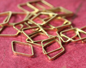 May include: A collection of small, gold-colored square-shaped metal jewelry findings. The findings are scattered on a red surface. The shapes are open in the center and have rounded corners. These findings are suitable for jewelry making and crafting.