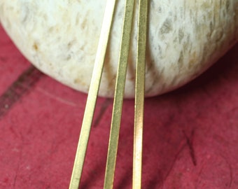 May include: Three gold metal bars with a small hole at the top. The bars are about 1 inch long and 1/8 inch wide.