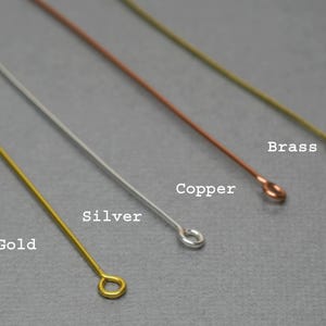 May include: Close-up of four metal wires with looped ends. The wires are gold, silver, copper, and brass. The words "Gold", "Silver", "Copper", and "Brass" are written next to each wire.